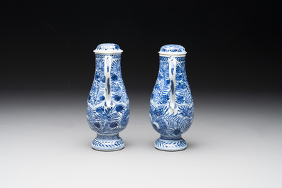 A pair of Chinese blue and white jugs and covers with floral design, Kangxi