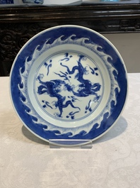 A pair of Chinese blue and white 'dragon' plates and a plate with narrative design, Yuzhen mark, Kangxi/Yongzheng