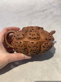 A Chinese Yixing stoneware reticulated double-walled teapot and a teapot with floral relief design, Kangxi