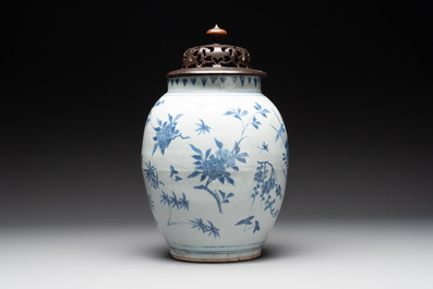 A Chinese blue and white vase with floral design and wooden cover, Transitional period