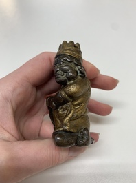 A small Chinese gilt bronze paperweight in the form of a kneeling foreigner, Ming