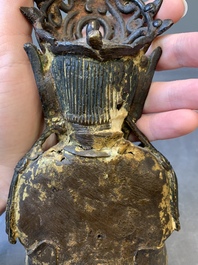 A Chinese parcel-gilt bronze Guanyin and wooden stand, Ming