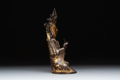 A Chinese parcel-gilt bronze Guanyin and wooden stand, Ming