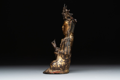 A Chinese parcel-gilt bronze Guanyin and wooden stand, Ming