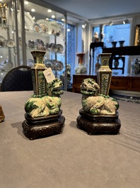 A pair of Chinese verte biscuit vases resting on Buddhist lions, Kangxi