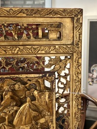 A pair of Chinese gilt-lacquered openworked wooden table screens with warriors on horseback, 19th C.