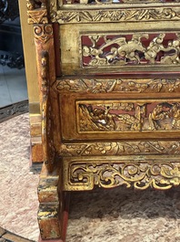 A pair of Chinese gilt-lacquered openworked wooden table screens with warriors on horseback, 19th C.