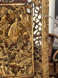 A pair of Chinese gilt-lacquered openworked wooden table screens with warriors on horseback, 19th C.