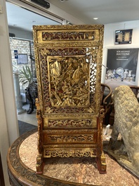 A pair of Chinese gilt-lacquered openworked wooden table screens with warriors on horseback, 19th C.