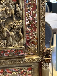 A pair of Chinese gilt-lacquered openworked wooden table screens with warriors on horseback, 19th C.
