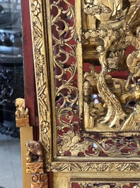 A pair of Chinese gilt-lacquered openworked wooden table screens with warriors on horseback, 19th C.