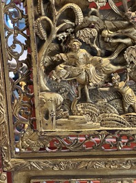 A pair of Chinese gilt-lacquered openworked wooden table screens with warriors on horseback, 19th C.
