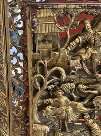 A pair of Chinese gilt-lacquered openworked wooden table screens with warriors on horseback, 19th C.