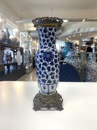 A pair of Chinese blue and white bronze-mounted vases and a covered jar, 19th C.