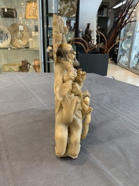 A Chinese carved group of a Luohan with two tigers, 20th C.