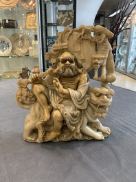 A Chinese carved group of a Luohan with two tigers, 20th C.