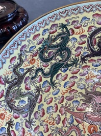 Two Chinese eggshell famille rose 'dragon' bowls on wooden stands, Qianlong mark, 20th C.