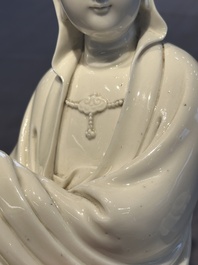A Chinese Dehua blanc de Chine figure of a seated Guanyin on wooden stand, 19/20th C.