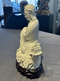 A Chinese Dehua blanc de Chine figure of a seated Guanyin on wooden stand, 19/20th C.