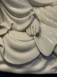 A Chinese Dehua blanc de Chine figure of a seated Guanyin on wooden stand, 19/20th C.