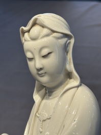 A Chinese Dehua blanc de Chine figure of a seated Guanyin on wooden stand, 19/20th C.