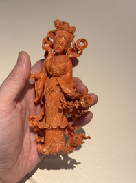 A Chinese red coral figure of a goddess on wooden stand, 19/20th C.