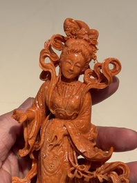 A Chinese red coral figure of a goddess on wooden stand, 19/20th C.
