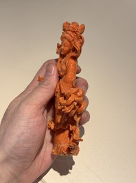 A Chinese red coral figure of a goddess on wooden stand, 19/20th C.
