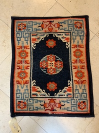 Two Tibetan saddle rugs and three small rugs, 19th C.