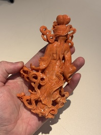 A Chinese red coral figure of a goddess on wooden stand, 19/20th C.