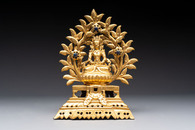 A Nepalese gilt-bronze Buddha on an inscribed throne with a mandorla, 19th C.