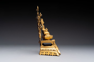 A Nepalese gilt-bronze Buddha on an inscribed throne with a mandorla, 19th C.