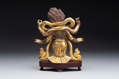 A Sino-Tibetan gilt-bronze figure of White Mahakala on wooden stand, 18th C.