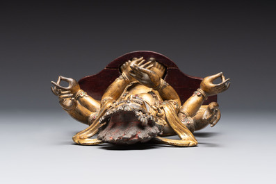 A Sino-Tibetan gilt-bronze figure of White Mahakala on wooden stand, 18th C.