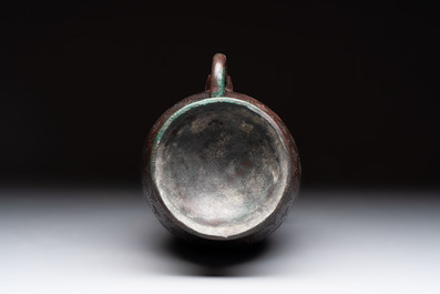 A Chinese archaic bronze inscribed wine vessel with scale design, 'hu 壺', Zhou