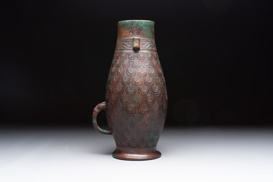 A Chinese archaic bronze inscribed wine vessel with scale design, 'hu 壺', Zhou