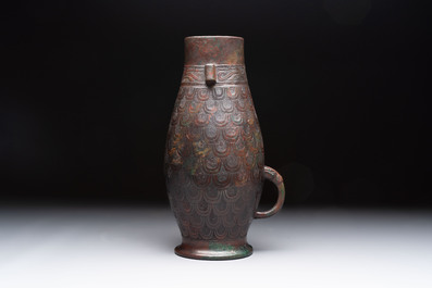 A Chinese archaic bronze inscribed wine vessel with scale design, 'hu 壺', Zhou
