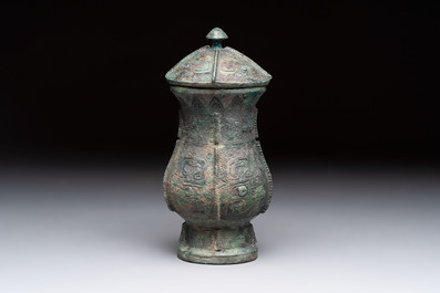A Chinese archaic bronze food vessel and cover with taotie design, 'zhi 觶', Shang