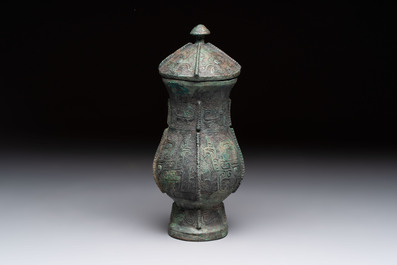 A Chinese archaic bronze food vessel and cover with taotie design, 'zhi 觶', Shang