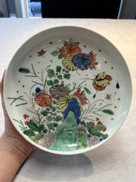 A Chinese gilt-decorated powder-blue plate and a famille verte plate with flowers, Kangxi/Qianlong