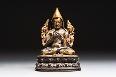 A Tibetan parcel-gilt bronze sculpture of a lama, 20th C.