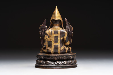 A Tibetan parcel-gilt bronze sculpture of a lama, 20th C.