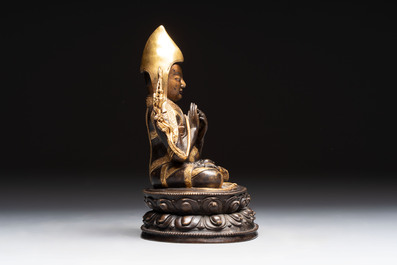 A Tibetan parcel-gilt bronze sculpture of a lama, 20th C.