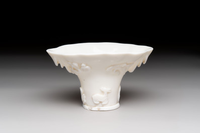 A Chinese Dehua blanc de Chine libation cup, a famille rose cup and two figures, 19th C.