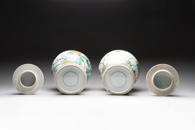 A pair of Chinese famille verte 'birds and flowers' vases and covers, 19th C.
