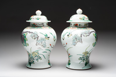 A pair of Chinese famille verte 'birds and flowers' vases and covers, 19th C.