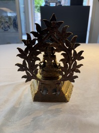 A Nepalese gilt-bronze Buddha on an inscribed throne with a mandorla, 19th C.