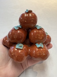 A pair of Chinese polychrome 'persimmons' groups on wooden stands, 19th C.
