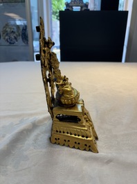 A Nepalese gilt-bronze Buddha on an inscribed throne with a mandorla, 19th C.