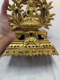 A Nepalese gilt-bronze Buddha on an inscribed throne with a mandorla, 19th C.
